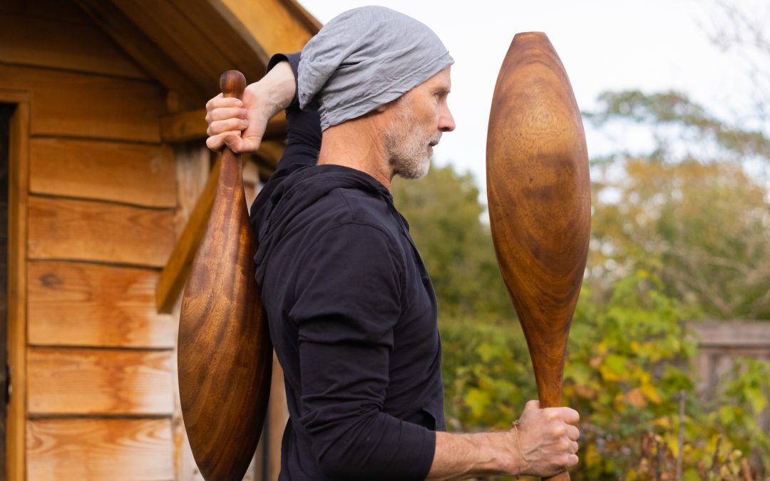 Man-Holding-Two-Large-Wooden-Indian-Clubs