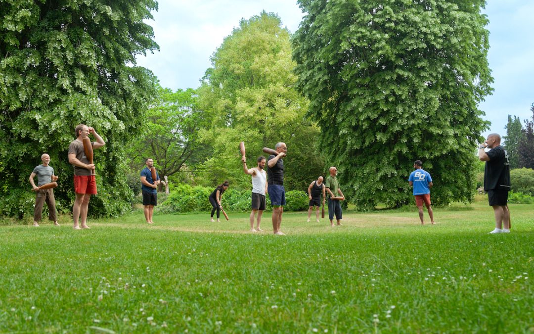 group-of-people-training-with-Indian-clubs-outdoors